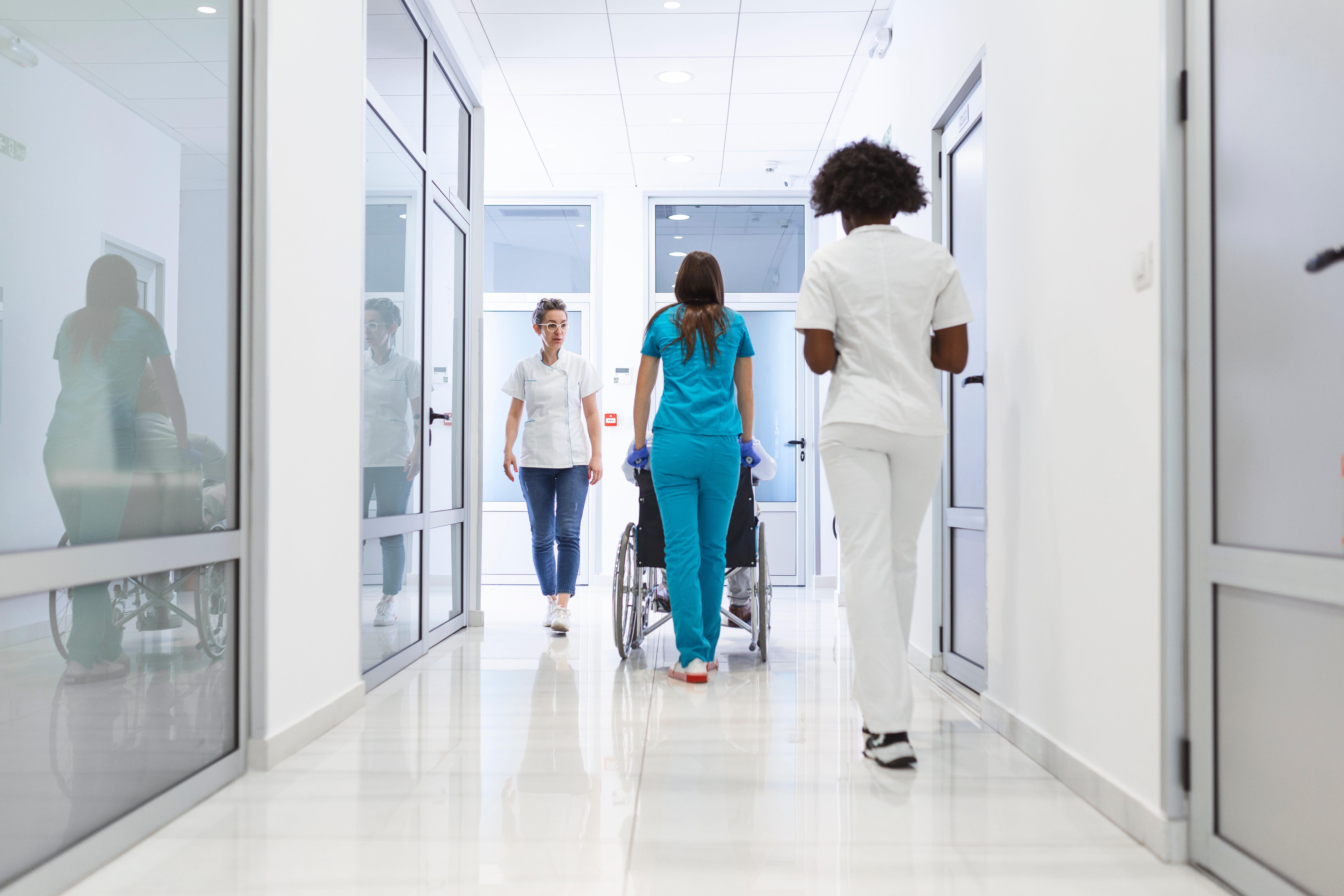 Hospital staff walking through halls with patient